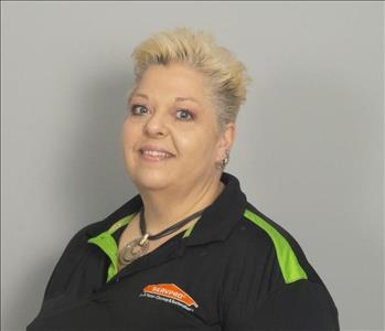 Female employee with yellow hair in front of gray background