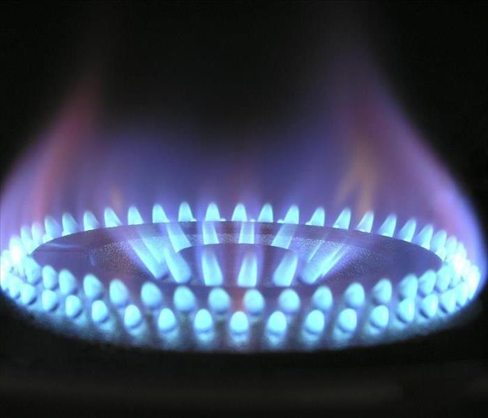 A blue stove top flame with a black background.